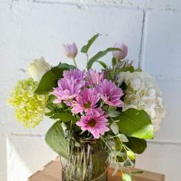 Pink daisies and hydrangeas in a glass vase