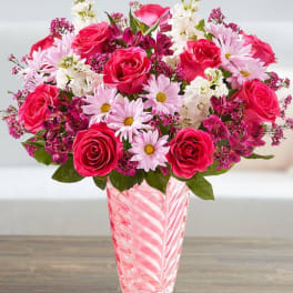 Pink roses and daisies in a striped glass vase