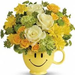 Yellow smiley-face mug filled with white and yellow flowers