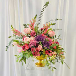 Pink and purple floral arrangement in a gold vase