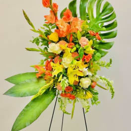 Tall tropical floral spray with orange and yellow blooms on a stand