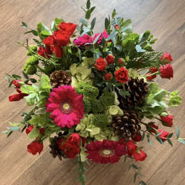Bouquet of red roses, pink gerbera daisies, and green hydrangeas with pinecones