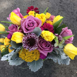 Bouquet of purple roses, yellow tulips, and mixed blooms