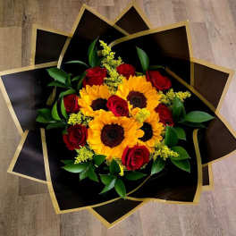 Bouquet of red roses and yellow sunflowers in black and gold wrap