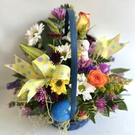 Colorful flower basket with daisies, roses, and a small bunny figurine