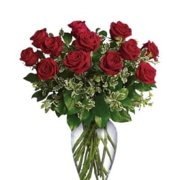 Red roses arranged in a clear glass vase
