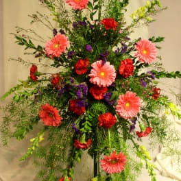 Tall standing floral spray with pink and red blooms