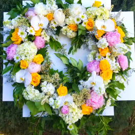 Heart-shaped floral wreath with white, pink, and yellow blooms