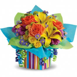 Bouquet of orange roses and yellow lilies in a striped gift box