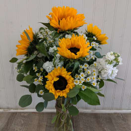 Sunflower bouquet in a glass vase with white filler flowers