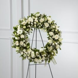 White floral wreath on a black stand
