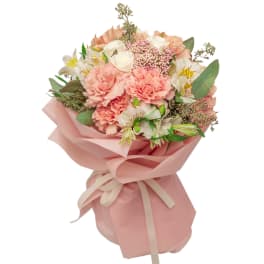 Pink and white bouquet wrapped in blush paper with a ribbon