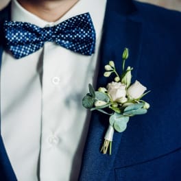 White rose boutonniere on a navy suit jacket