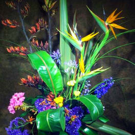 Tropical arrangement with bird-of-paradise and purple flowers