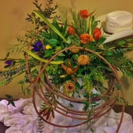 Large floral arrangement with a white cowboy hat and coiled rope