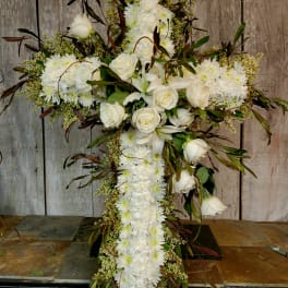 White floral cross arrangement with roses and daisies