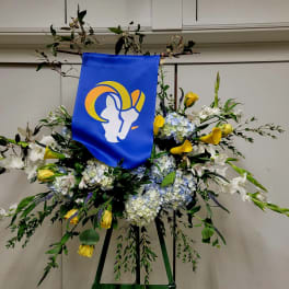 Large floral standing spray with blue banner and yellow-white flowers