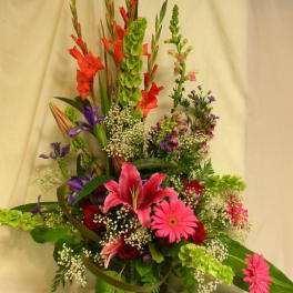 Tall mixed flower arrangement with pink lilies and gerbera daisies in a vase