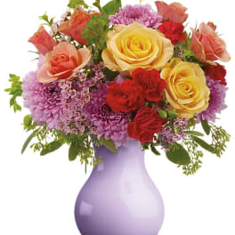 Mixed bouquet of roses and purple chrysanthemums in a lavender vase