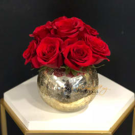 Red roses arranged in a gold mirrored vase