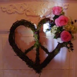 Heart-shaped floral wreath with pink roses on a door
