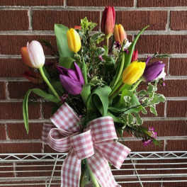Mixed tulip bouquet in a glass vase with a pink gingham bow