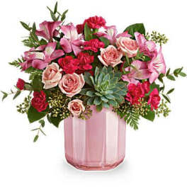 Pink and red flower arrangement in a pink glass vase