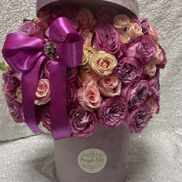 Pink and purple roses in a lavender hatbox with a satin ribbon