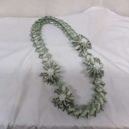 Dollar bill lei with small white flower accents