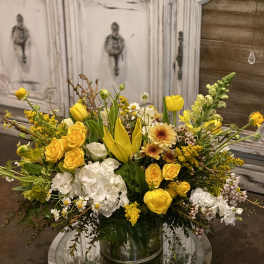 Yellow and white mixed flower arrangement in a clear glass vase