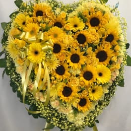 Heart-shaped yellow floral standing spray with sunflowers and roses