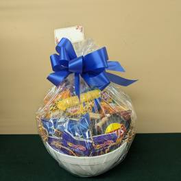 Gift basket of assorted snacks in a white bowl with a blue bow