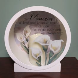 Round memorial plaque with white calla lilies and a sympathy quote