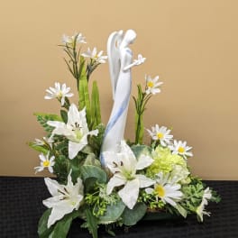 White floral arrangement with a central angel figurine