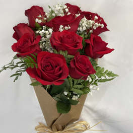 Bouquet of red roses with baby's breath wrapped in brown paper