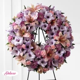 Lavender and pink floral wreath on a black stand