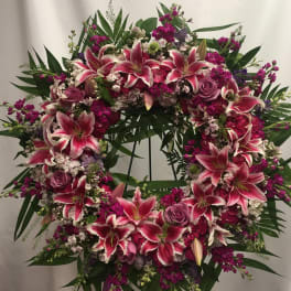 Large pink and white lily wreath with roses on a stand
