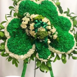 Large green and white floral standing spray with a ribbon bow