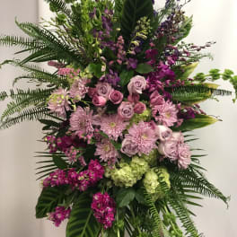 Large standing floral spray with pink roses and purple blooms