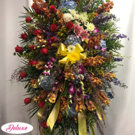 Large standing spray with red roses, blue hydrangeas, and yellow ribbon