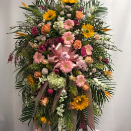 Large standing floral spray with pink and yellow flowers and ribbon