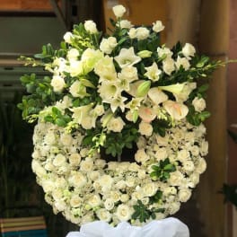 Large white floral standing spray with roses and lilies