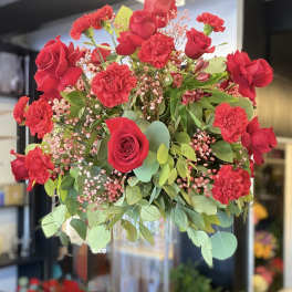 Red roses and carnations in a clear glass vase