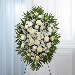 White funeral spray with daisies and roses on a standing easel
