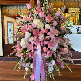 Large pink and white floral standing arrangement with ribbon