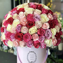 Large bouquet of multicolored roses in a pink hatbox