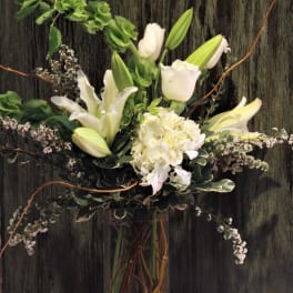 White lilies and hydrangea in a tall glass vase