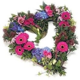 Heart-shaped floral wreath with pink gerberas and blue hydrangeas