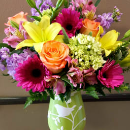 Colorful bouquet with lilies, roses, gerbera daisies, and alstroemeria in a green vase