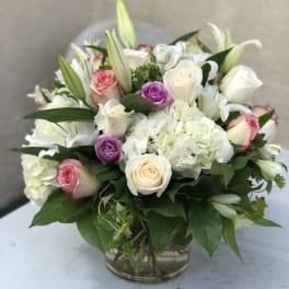 Mixed bouquet of white and pink roses with lilies in a glass vase